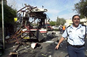An Israeli Police officer works at the scene of a public bus bombing in the northern Israeli city of Haifa