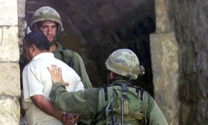 Israeli soldiers arrest a Palestinian in the West Bank town of Nablus