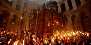 Gläubige halten in der Grabeskirche Kerzen in die Höhe, die sie zuvor am heiligen Feuer angezündet hatten. (Bild: AFP)