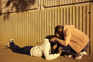 Young Israeli women take coveras a siren sounds warning about incoming rocket fired from Gaza, in the southern Israeli city of Ashkelon,