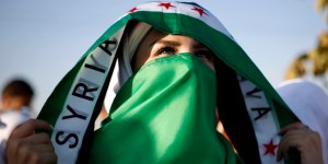 Eine syrische Frau mit den Symbolen der Opposition.  (Bild: reuters)