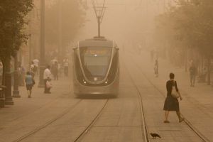 Israelis walk across the lightrail tracks on Jaffa road in Jerusalem on September 8, 2015, as a  sand storm hit across Israel. Photo by Yonatan Sindel/Flash90 *** Local Caption *** àåáê ñåôú çåì øçåá éôå éøåùìéí îæâ àåéø